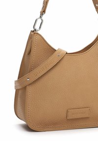 Vaaleanruskea nahkainen käsilaukku, jossa on sileä pinta, kaareva muoto ja irrotettava hihna. Varaus takaa brändilogo ja hopeanvärisiä metalliosia.