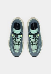 Αθλητικά παπούτσια με άνω μέρος από δίχτυ σε πράσινο τιρκουάζ και ανοιχτό πράσινο, επένδυση στον γιακά, μαύρα κορδόνια και ανοιχτόχρωμη σόλα με υφή.