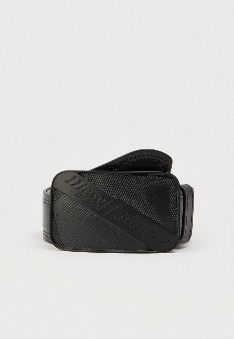 Μαύρη ζώνη με υφή και έντονο ανάγλυφο λογότυπο. Το υλικό φαίνεται λείο με φινίρισμα που μοιάζει με δέρμα.