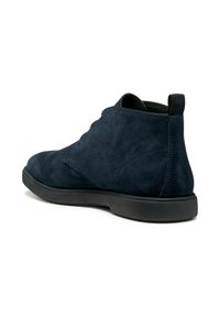 Bottines en suède bleu marine avec un bout rond, texture lisse et semelle en caoutchouc noir. Présente une languette à l'arrière et un laçage minimal.