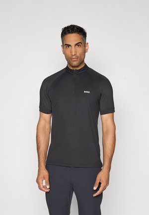 Schwarzes Poloshirt mit kurzen Ärmeln, das für Leistung ausgelegt ist. Es verfügt über einen Reißverschlusskragen und ein erhabenes Logo auf der Brust, gefertigt aus einem glatten, elastischen Stoff.