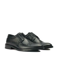 Black leather brogue shoes with decorative perforations, lace-up design, rounded toe, and a low-profile sole.