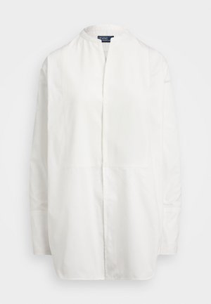White long-sleeve shirt with a band collar, featuring a textured panel at the front and a straight-cut design. Smooth fabric texture.