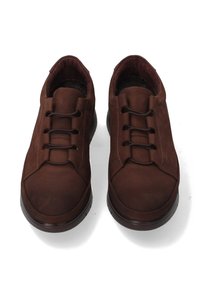 Ein Paar braune lässige Leder-Slipper mit elastischen Schnürsenkeln und schwarzen Gummisohlen, von oben auf einem weißen Hintergrund gezeigt.