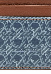 Kabelka Coccinelle s geometrickým námořnickým vzorem, hnědými koženými akcenty a texturovaným povrchem se viditelným prošíváním a detailem loga.