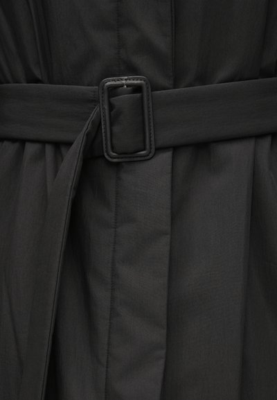 Čierne šaty s opaskom, ktoré majú hladkú matnú textúru a štruktúrovaný strih s záhybmi. Pracka je obdĺžnikov�ého tvaru s zaoblenými hranami.