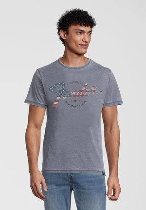 Graues Baumwoll-T-Shirt mit rundem Halsausschnitt, das mit einem verwaschenen "Fender"-Logo in Rot und Blau sowie Sternakzenten versehen ist. Kurze Ärmel, lässiger Schnitt.