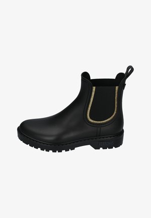 Botín chelsea negro de goma con acento elástico dorado, punta redondeada, suela texturada y tirador en la parte trasera. Branding visible en el lateral.