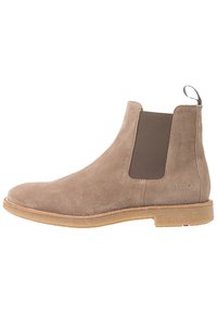 Tan suede Chelsea-nilkkurit, joissa on elastiset sivupaneelit ja vetotab. Pyöristetty kärki ja vaalean tan värinen pohja. Vähäiset yksityiskohdat ja tyylikäs profiili.