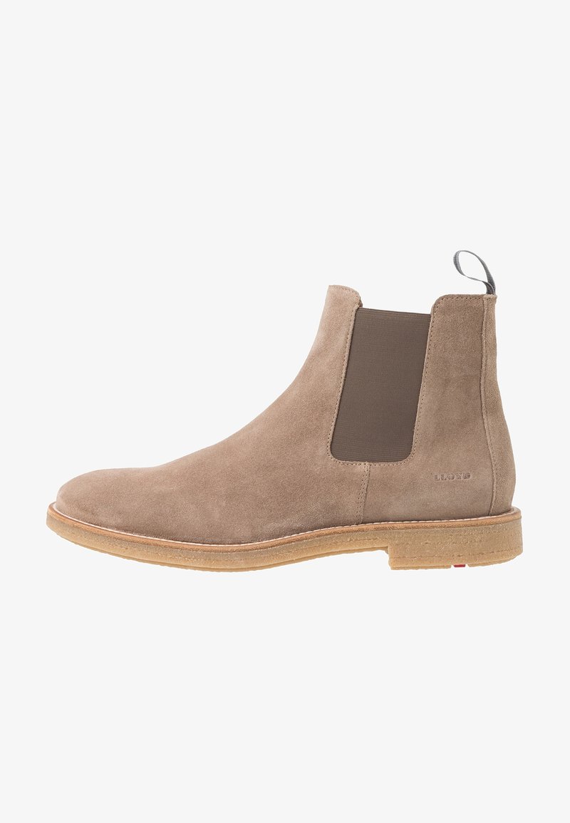 Tan suede Chelsea-nilkkurit, joissa on elastiset sivupaneelit ja vetotab. Pyöristetty kärki ja vaalean tan värinen pohja. Vähäiset yksityiskohdat ja tyylikäs profiili.