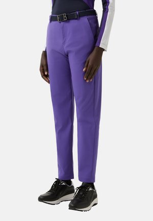 Lilla chinos med en slank pasform, der har et vævet sort bælte og sidelommer. Kombineret med sorte sneakers, der fremhæver et sporty udseende.