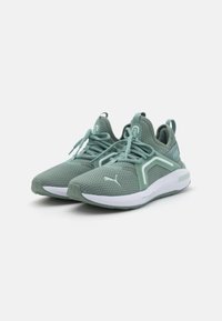 Zapatillas deportivas de tejido de malla verde claro, con una suela blanca acolchada, parte superior texturizada y acentos en contraste con cordones.