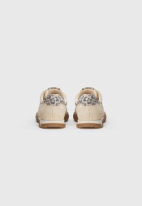 Beige semskinn-sneakers med leopardmønster detaljer på hælen og en strukturert gummis�åle. Minimalistisk design med polstret krage.
