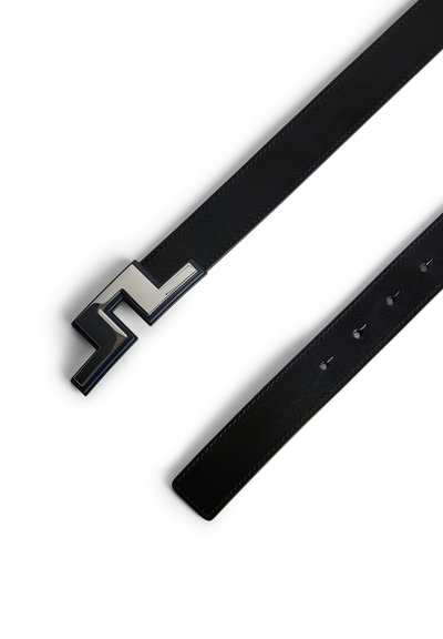 Zwart leren riem met een slanke, hoekige zilveren gesp die een opvallend zigzagontwerp heeft en meerdere verstelgaten op de band.