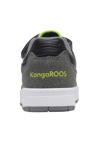 Graue Wildleder- und schwarze Leder-Sneaker mit weißer Sohle, ausgestattet mit einem hellgrünen Akzent und Logo an der Rückseite. Texturiertes Obermaterial und robuste Bauweise.