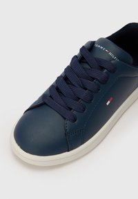 Mørkeblå lærersneakers med rund tå, teksturert overflate, kontrasterende hvit såle og mørkeblå snørebånd. Har små logo detaljer.