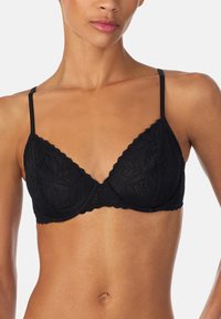 Zwarte kanten beha met getande randen, driehoekige cups en verstelbare dunne bandjes. Heeft een gestructureerd bloemenpatroon. Geen vulling.