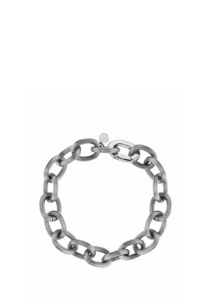 Bracciale a catena in argento con grandi maglie ovali e una targhetta rotonda alla chiusura su sfondo bianco.