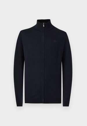 Marineblå hettejakke med glidelås, høy krage, lange ermer og en subtil logo. Laget av mykt, strukturert stoff med en figurnær design.