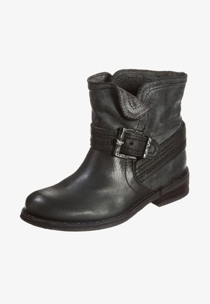 Bottine en cuir noir avec un revers plié, une bride décorative cousue et une boucle en argent sur le côté.