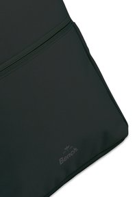 Coin du sac à dos en tissu vert, avec un matériau texturé, comportant une fermeture éclair horizontale et le logo "Bench." imprimé en gris clair.