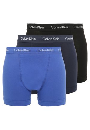 Drei Paar Calvin Klein Boxer-Shorts in Blau, Marineblau und Schwarz. Weiches Baumwollmaterial mit kontrastierenden weißen Logos am Bund.