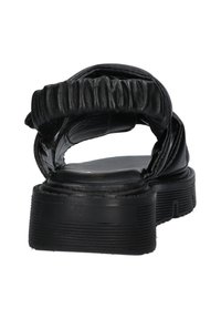 Zwarte leren sandaal met een gerimpeld bandontwerp, vlakke zool en een gestructureerde rubberen zool. Beschikt over een eenvoudige en open achterkant voor gemakkelijk aan- en uittrekken.