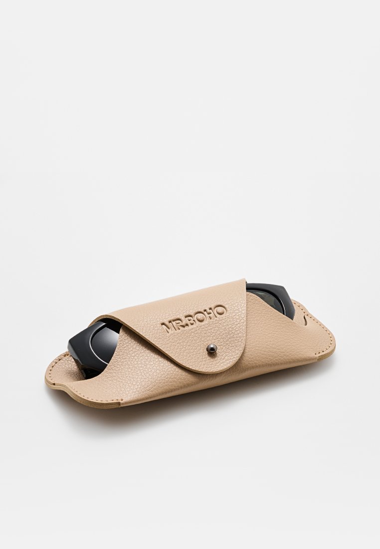 Étui à lunettes en cuir beige avec finition texturée, bords arrondis et fermeture à pression. Nom de la marque "MR. BOHO" embossé à l'avant.