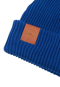 Niebieska czapka dziana z prążkowaną teksturą, z brązową skórzaną łatą z wytłoczonym motywem góry.
