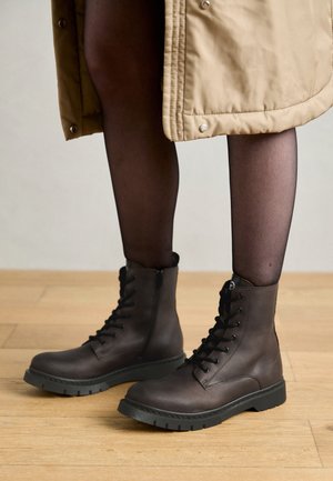Brown lace-up boots made of leather with a textured surface and a black rubber sole, featuring a zipper and sturdy eyelets.
