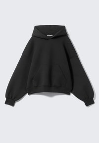 Svart oversize hoodie med snörning i huvan, ribbade muddarna och en framficka. Tillverkad av mjukt, texturerat tyg med en avslappnad passform.