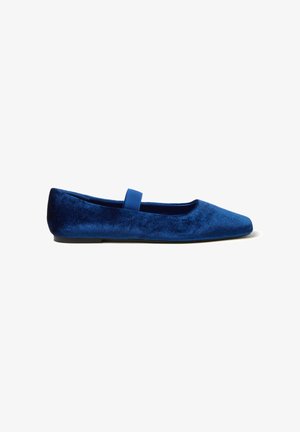 Ballerines en velours bleu avec un bout pointu et une petite sangle élastique sur le cou-de-pied. Texture douce et semelle à profil bas.