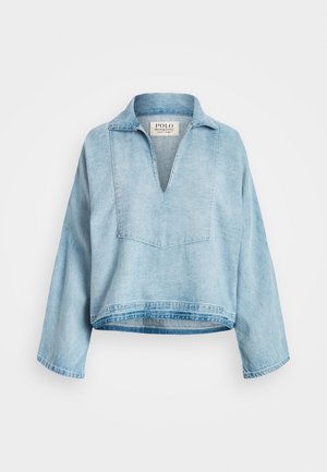Jasnoniebieski denimowy pulower z długim rękawem, szerokim dekoltem w kształcie litery V i luźnym krojem, z metką Polo Denim & Supply od wewnątrz kołnierza.