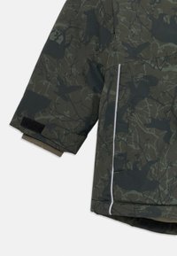Børns mørkegrønne camouflagejakkeærme med sort dyre- og grenmønster, velcrorem ved manchetten og reflekterende kant nær lommen.