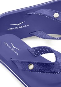 Violetti flip-flopit, joissa on sileä matta pinta, pisteillä varustetut remmit ja hopeiset yksityiskohdat. "VENICE BEACH" -logo näkyy jalkapohjassa.