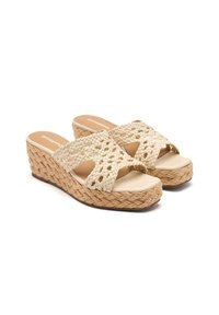 Sandales compensées tissées beiges avec des sangles à motif croisé, une semelle lisse et une plateforme texturée semblable au jute. Design léger.