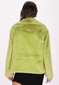 Faux furjakke i strålende limegrøn med en blød tekstur. Har en afslappet pasform, lange ærmer og et kravefrit design.