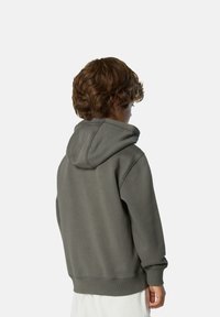 Kapuzensweatshirt aus dunkelgrauem Baumwollmix. Mit gerippten Bündchen und Saum, sowie sichtbaren Nähdetails auf der Rückseite.