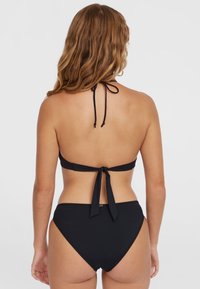 Čierny bikiny, halter top s viazanými ramienkami, spodný diel s miernym zakrytím. Hladká tkanina, minimalistický dizajn, žiadne viditeľné vzory ani ozdoby.