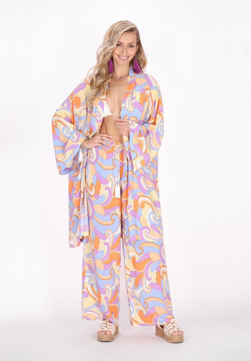 Costum colorat din două piese, care include un top de stil kimono și pantaloni largi cu un model spiralat în culori pastelate. Material ușor, croială lejeră.