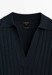 Dark blue ribbed knit polo shirt with a V-neckline and a structured collar. Tags read "Massimo Dutti" and "Made in Turkey."