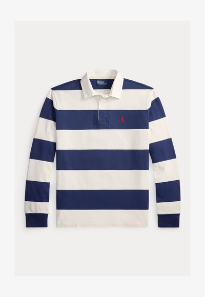 Πολο μπλούζα με μακριά μανίκια σε ναυτικό μπλε και λευκές ρίγες, με κλασικό γιακά και μικρό κόκκινο λογότυπο στο στήθος. Κατασκευασμένη από βαμβάκι.