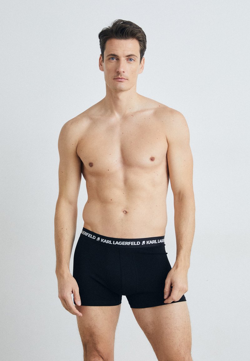 Zwarte katoen boxershorts met een strakke pasvorm, voorzien van een gebrandmerkte tailleband met de tekst "KARL LAGERFELD" in het wit. Minimalistisch ontwerp, gladde textuur.