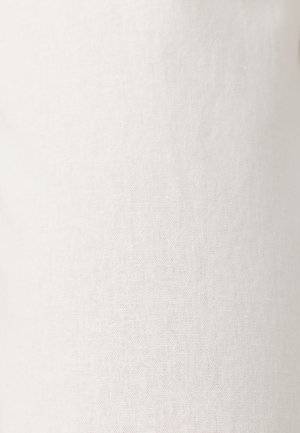 Tissu blanc texturé avec un motif tissé subtil, éclairé uniformément sans plis ni rides visibles.