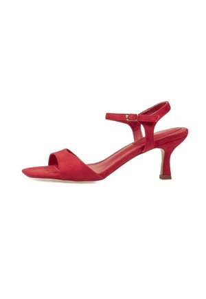 Sandalia de mujer de ante rojo con tacón bajo tipo 'kitten', puntera abierta y pulsera en el tobillo con hebilla sobre fondo blanco.