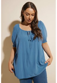 Blå blus i lätt tyg, med gathered korta ärmar, rund halsringning och en frontknutdetalj. Slät textur, avslappnad passform.