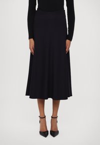 Musta midi-hame, joka on valmistettu sileästä kankaasta, A-linjaisella muotoilulla, leveällä vyötärönauhalla ja hienovaraisella helman levennyksellä. Yhdistetty mustiin terävyöjalkineisiin.