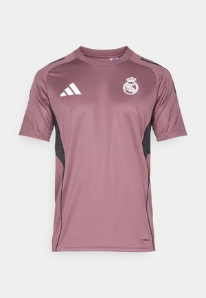 Męska koszula z krótkim rękawem w ciemnym odcieniu mauve z czarnymi bocznymi panelami. Z biały logo Adidas i emblemat Realu Madryt. Gładki, lekki materiał.