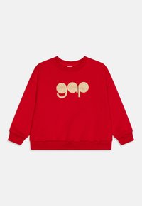 Felpa rossa con maniche lunghe, polsini e orlo a costine. Presenta un logo "gap" dorato e luccicante sulla parte anteriore in un font arrotondato.