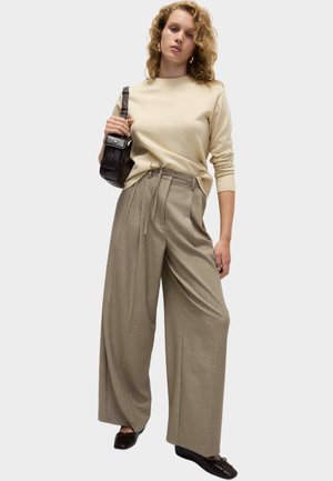 Maglione beige con scollatura rotonda, abbinato a pantaloni marrone chiaro a vita alta con cintura da annodare e gamba larga. Inclusa borsa nera.